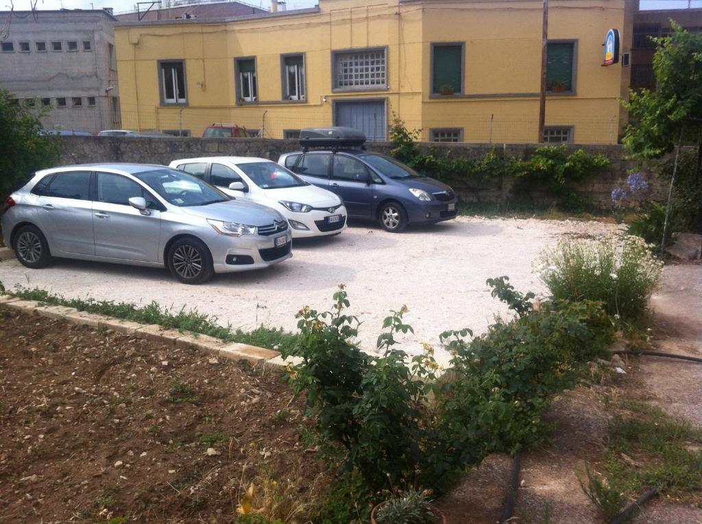 trzy samochody zaparkowane na parkingu przed budynkiem w obiekcie Accogliente Dimora w mieście Putignano