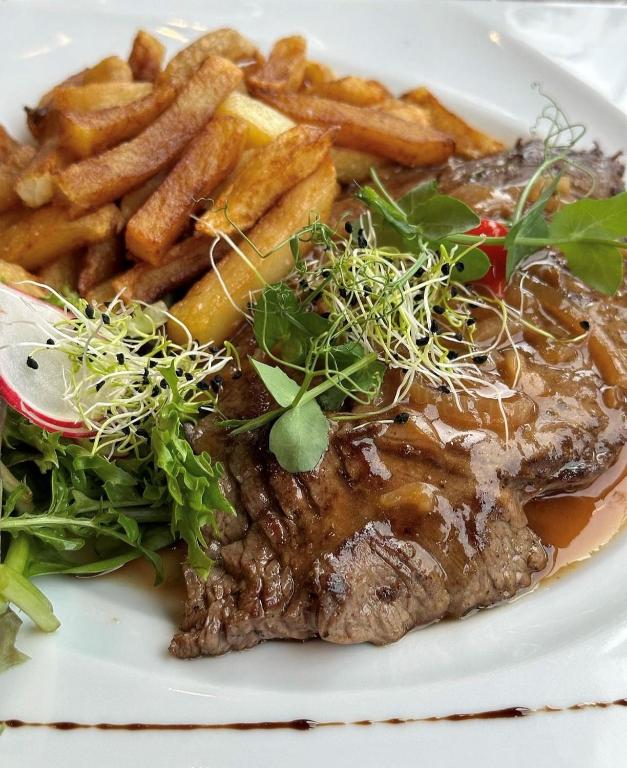 a plate of food with steak and french fries at Hôtel du Musée in Granville