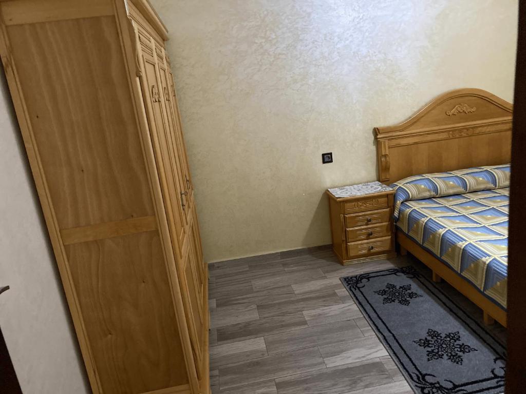 a bedroom with a bed and a dresser next to a door at residence andalucia in Larache