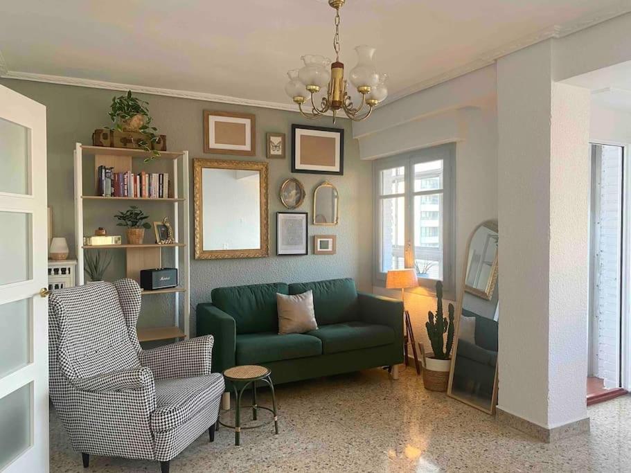 a living room with a green couch and a chair at Acogedor apartamento a 5 min del Ave in Zaragoza