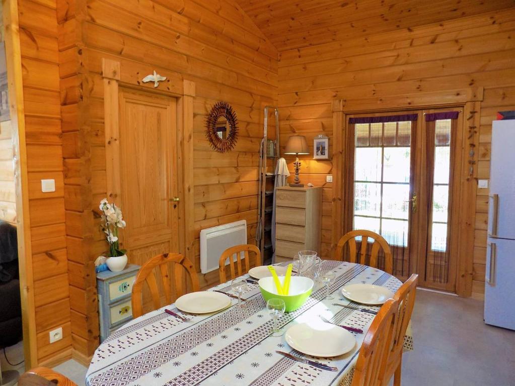 a dining room with a table and chairs in a cabin at Les Mathes La Palmyre - MAISON CABANE des TRAPPEURS - PROCHE COMMERCES in Les Mathes
