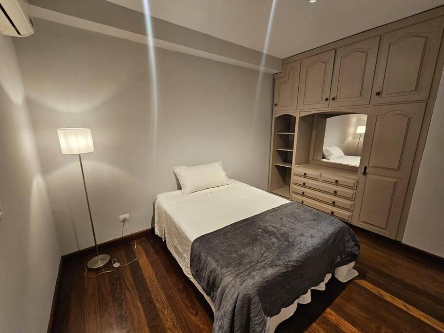 a small bedroom with a bed and a dresser at Apartamento bien localizado in Ciudad del Este