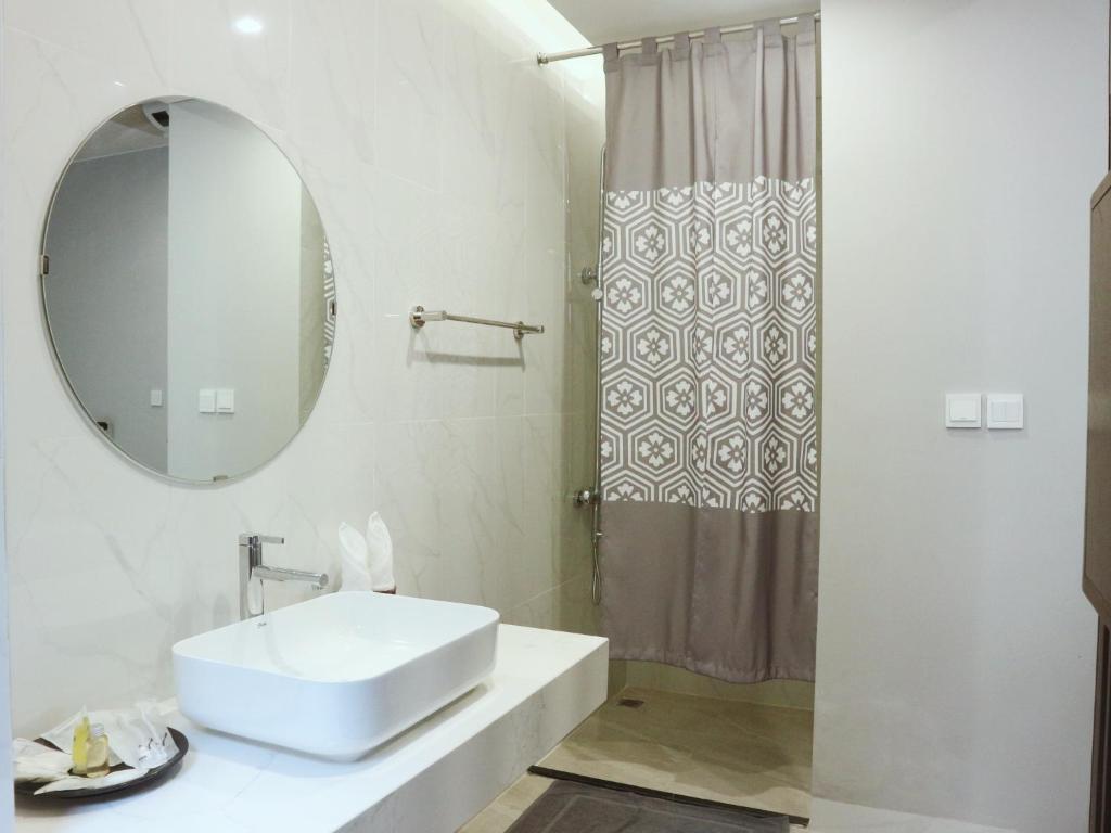 uma casa de banho branca com um lavatório e um espelho em Fuwa Fuwa Home - Wyndham Lynn Times Thanh Thủy- Khu nghỉ dưỡng Khoáng nóng em Phú Thọ