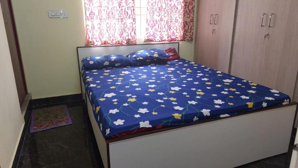 ein Schlafzimmer mit einem Bett mit blauer Decke mit Sternen in der Unterkunft Stayzilla Santhoshini Homes 2 BHK in Vellore