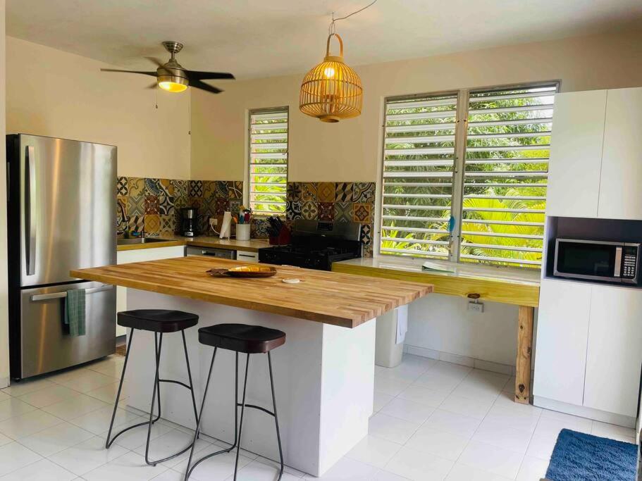 a kitchen with a wooden counter and stools at 3 Bedroom Retreat in Rincon Casa Pina Suave, Rustic with Yard & Patio in Rincon