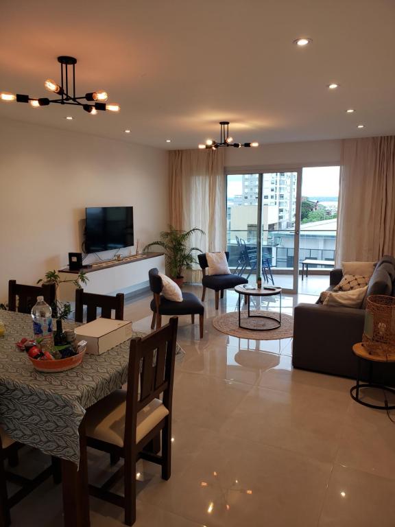 un soggiorno con divano e tavolo di Departamento Nuevo con Vista al Río - Edificio Marwa - Zona Residencial a Posadas