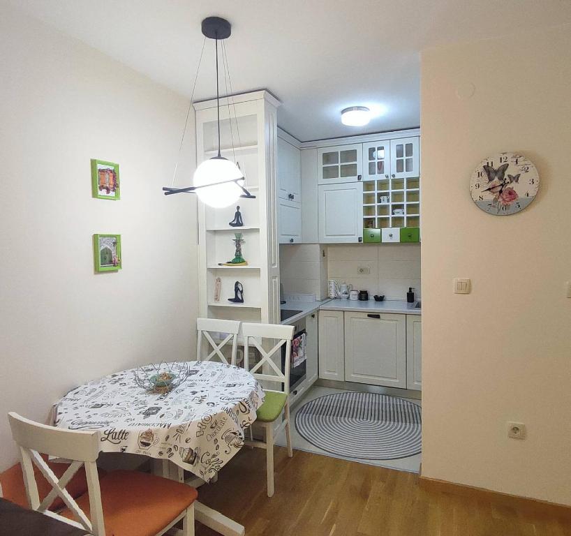 a small kitchen with a table and a dining room at CITY POINT Apartment in Podgorica