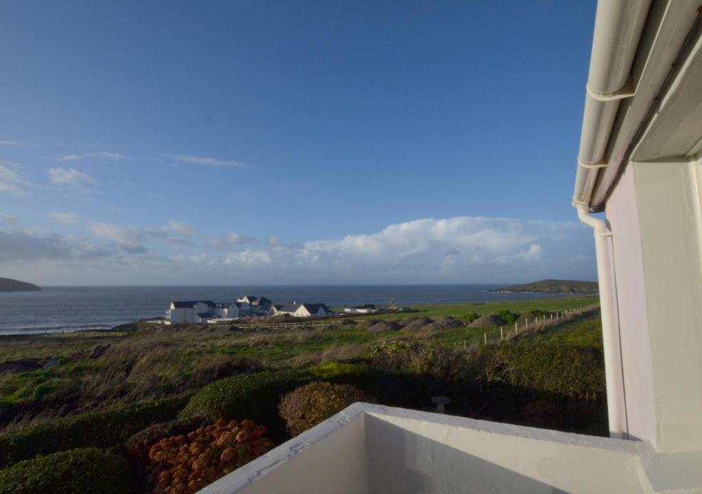 a view of the ocean from the balcony of a house at Fourwinds in Towyn