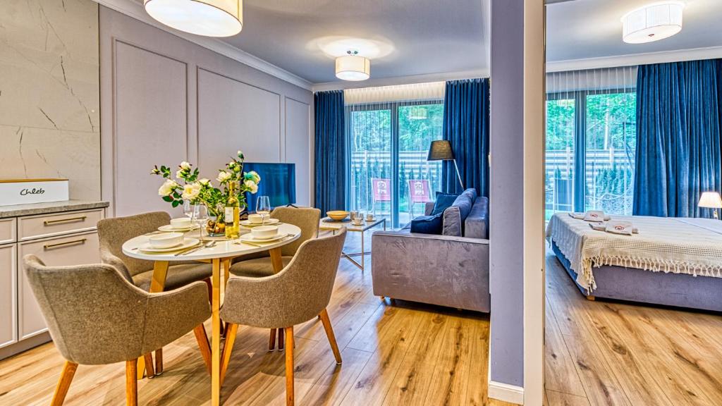 una habitación con mesa y sillas y un dormitorio en Rezydencja Niechorze 124 - 5D Apartamenty en Niechorze
