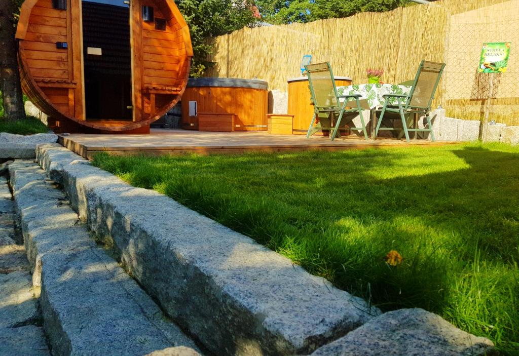 un jardín con mesa y sillas en un patio en Alpakowy raj en Nowy Targ