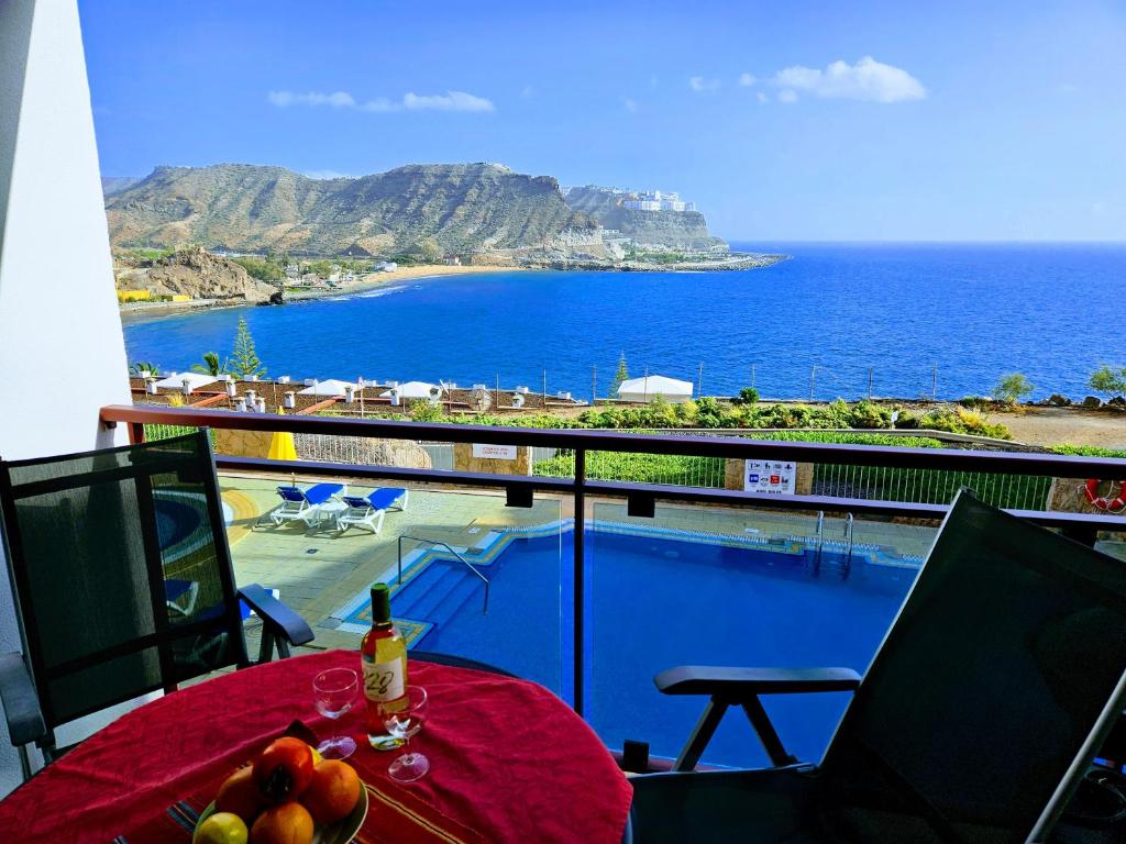 una mesa con fruta en la parte superior de un balcón con vistas al océano en Residence Ocean View, en Mogán