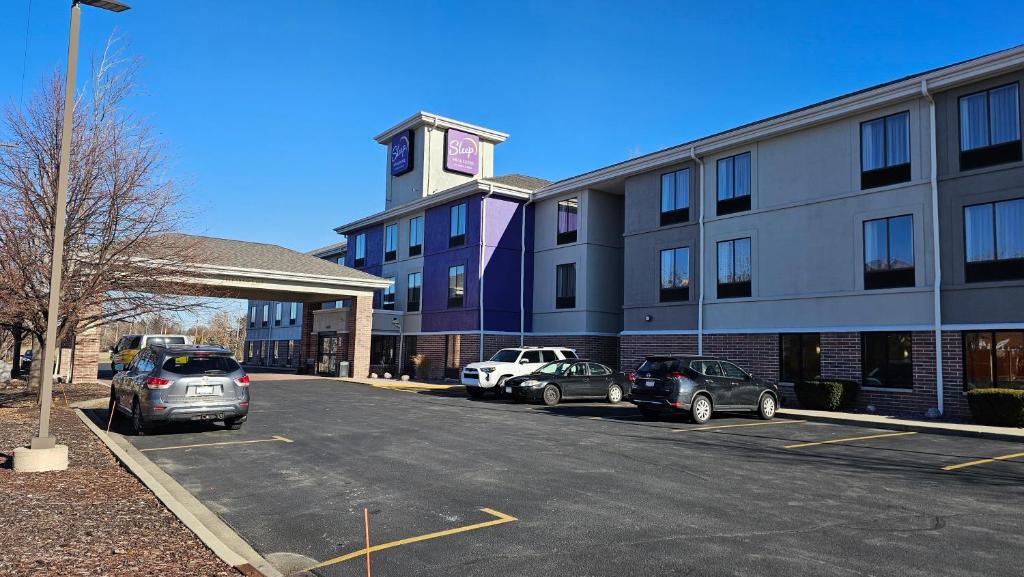 a parking lot in front of a building with a clock tower at Sleep Inn & Suites Milwaukee Airport in Milwaukee