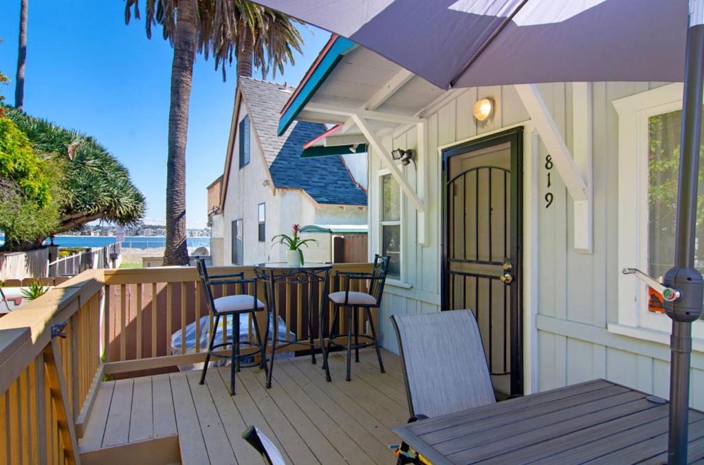 - une terrasse couverte avec des chaises, une table et un parasol dans l'établissement Mission Bay Cottage - Bay View Patio, Parking, WasherDryer, à San Diego