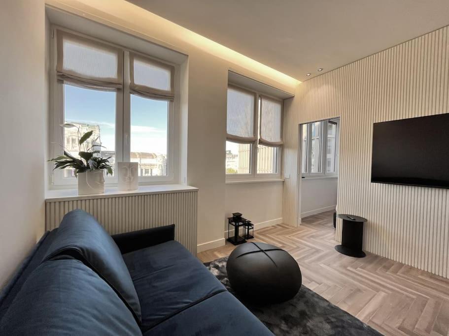 un soggiorno con divano blu e TV a schermo piatto di YLS Luxury Suites 2 a Milano