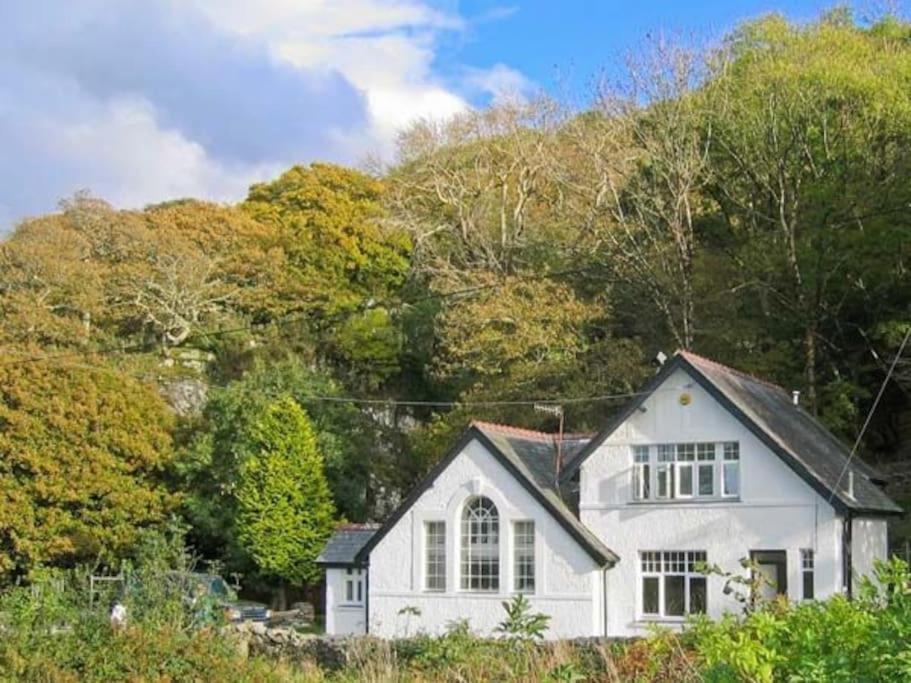 a white house in front of a mountain at Holiday Cottage in Snowdonia (Sleeps 10) in Harlech