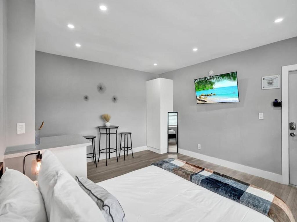 a white bedroom with a bed and a table at Coastal Charm Studio Retreat near Pompano Beach in Pompano Beach