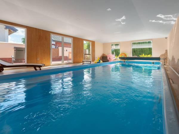 a large blue swimming pool in a building at Willa Ariadna in Jastrzębia Góra