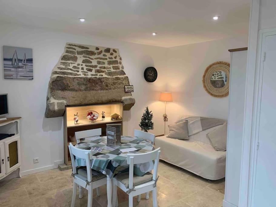 a room with a bed and a table and a bedroom at La petite Bretonne in Plounérin