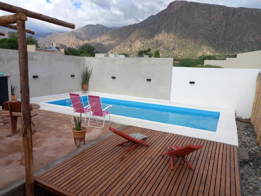 una terraza con 2 sillas y una piscina en cabaña merlot en Cafayate