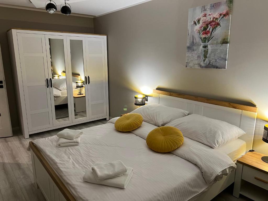 a bedroom with a large white bed with yellow pillows at Apartament CITY Ustroń in Ustroń