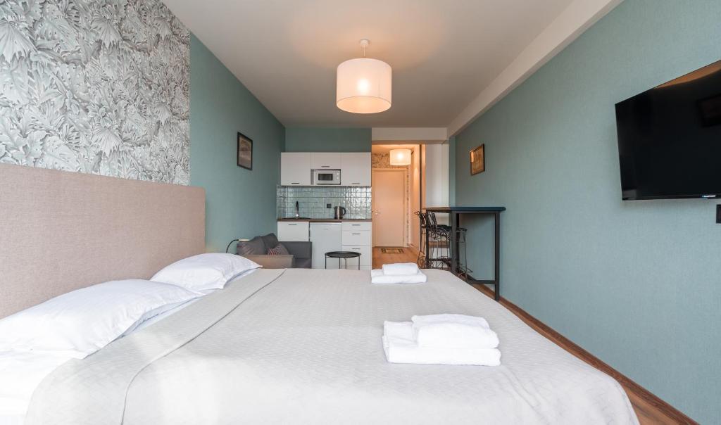 a bedroom with a large white bed with towels on it at Kudebi apartments, Twins new Gudauri in Gudauri