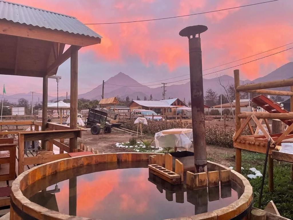 una piscina de agua con una puesta de sol en el fondo en Cabaña La campana, en Hijuelas