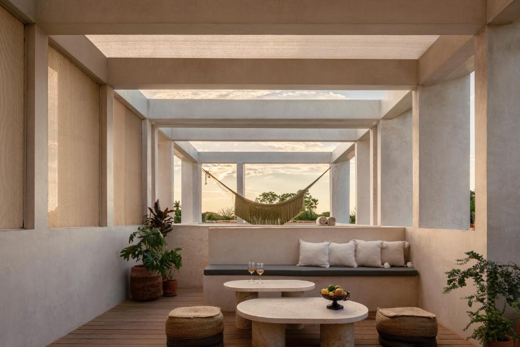 een kamer met 2 tafels en een hangmat bij Hotel Sureño Yucatan in Mérida