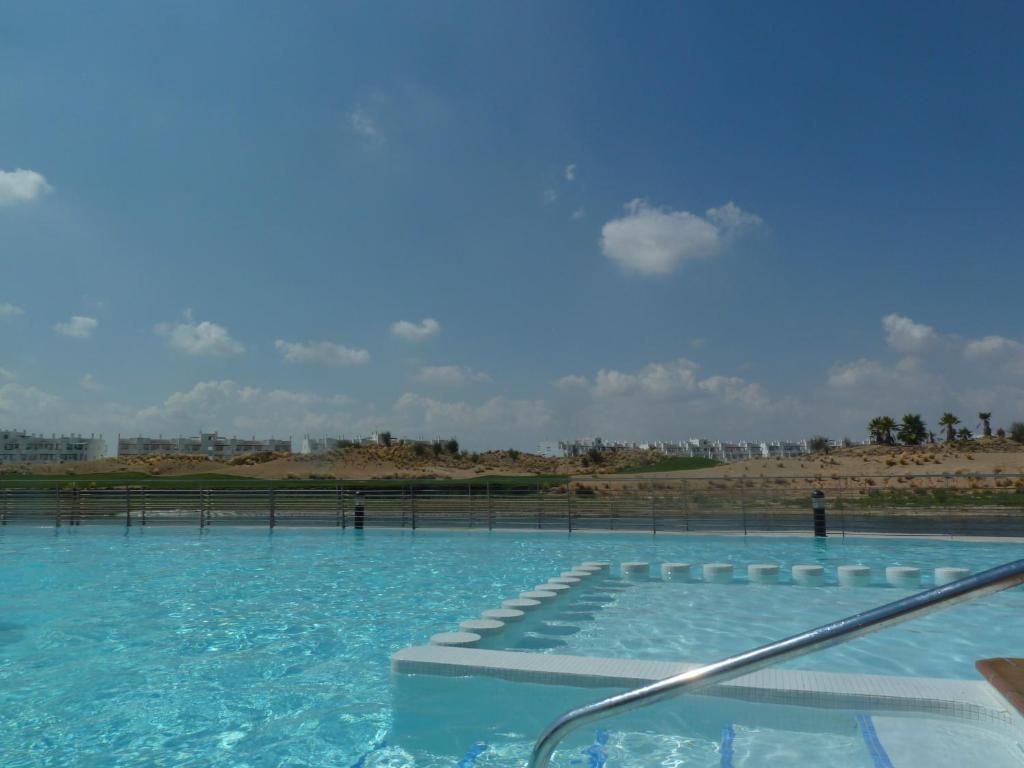a large swimming pool with blue water at Apartamento Isla de Terrazas de la Torre in Roldán