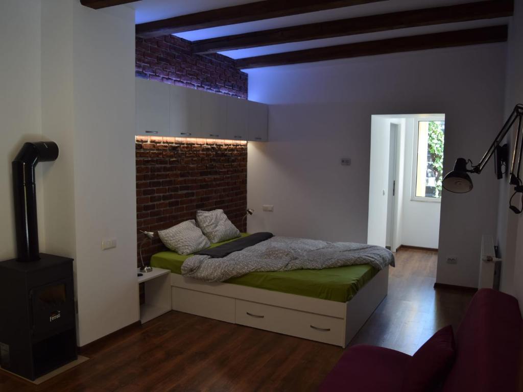 1 dormitorio con cama y pared de ladrillo en BrasovApart Republicii en Braşov