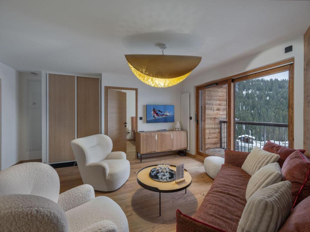 un salon avec un canapé, des chaises et un lustre dans l'établissement Appartement moderne 6 pers proche pistes avec parking, casier à ski, balcon - FR-1-563-140, à Courchevel