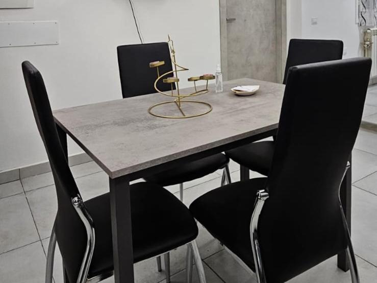 mesa de comedor con sillas negras y mesa de madera en LAKE HOUSE CANZO, en Canzo