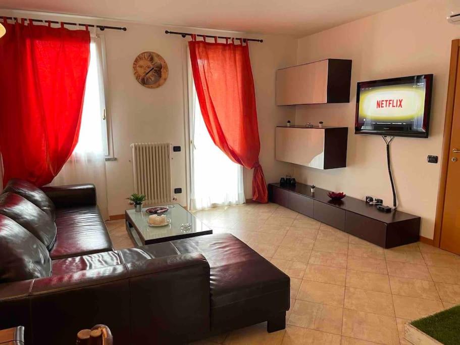 sala de estar con sofá y TV de pantalla plana en Bellissima vicino al lago di Como Lecco climatizzata barbecue, en Suello