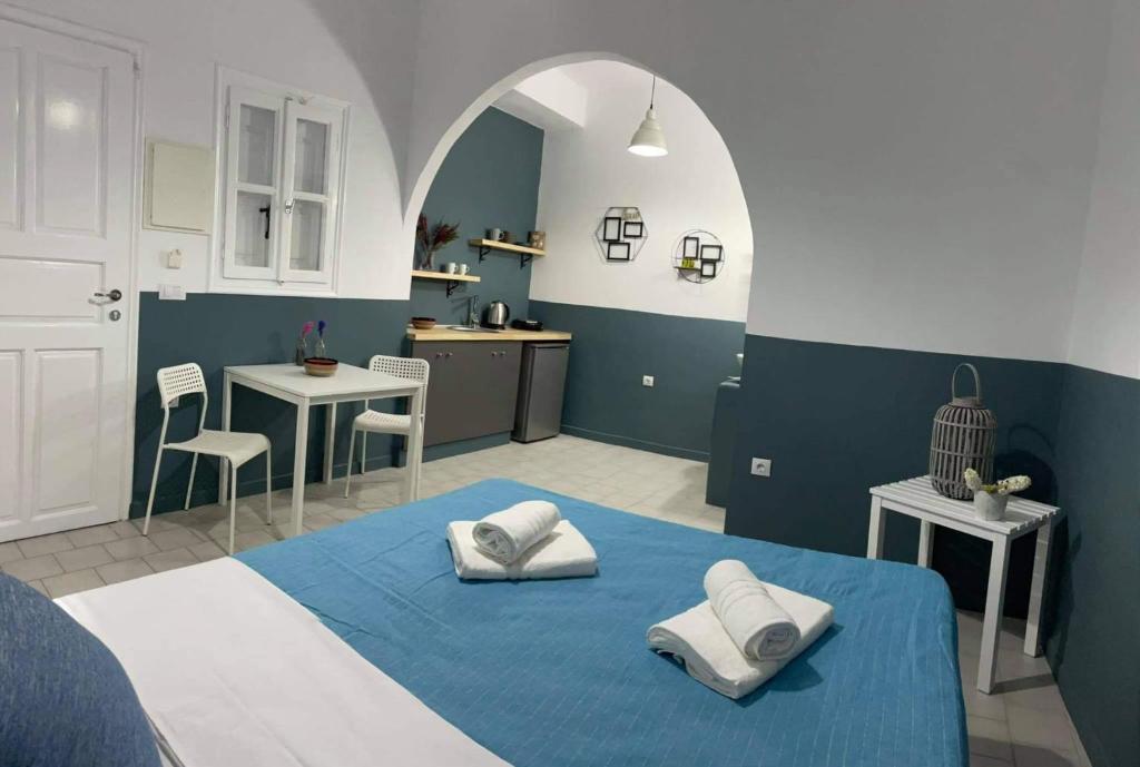 Jest to niebiesko-biały pokój z łóżkiem i kuchnią. w obiekcie Sabbia Calda Apartments w mieście Perissa