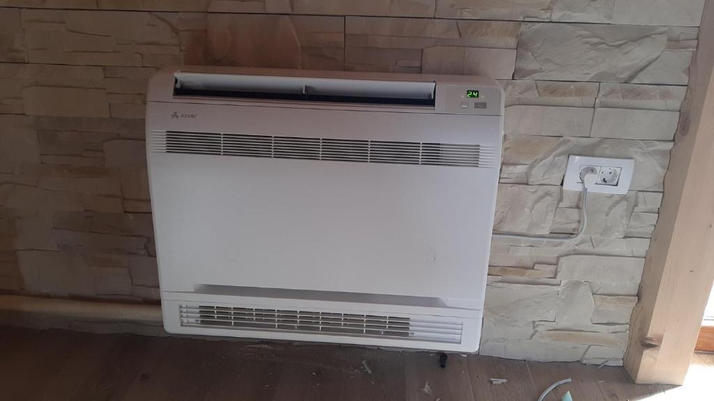 a white heater sitting next to a stone wall at House Bojana in Žabljak