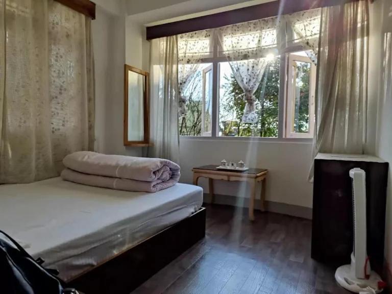 - une chambre avec un lit et une fenêtre dans l'établissement BaalaChhen Urban Home Stay, à Gangtok