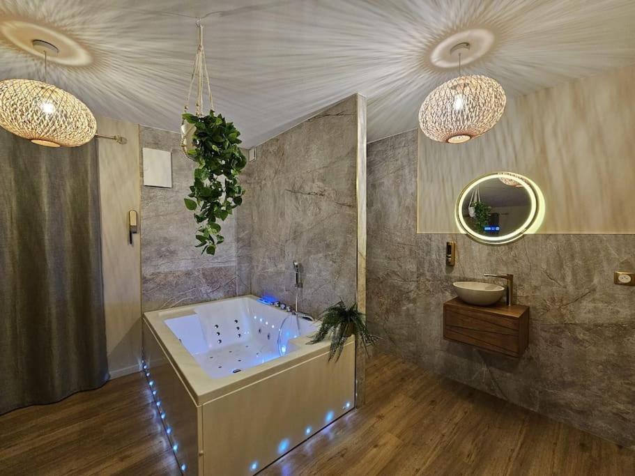 baño grande con bañera y espejo en La Parenthèse - Votre Cocon au Centre d'Oyonnax, en Oyonnax