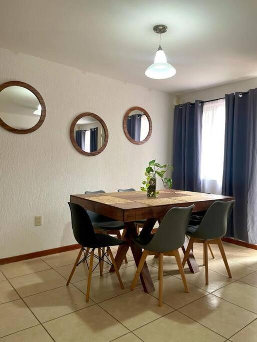 a dining room with a wooden table and chairs at Descansa en un espacio acogedor in Guadalajara