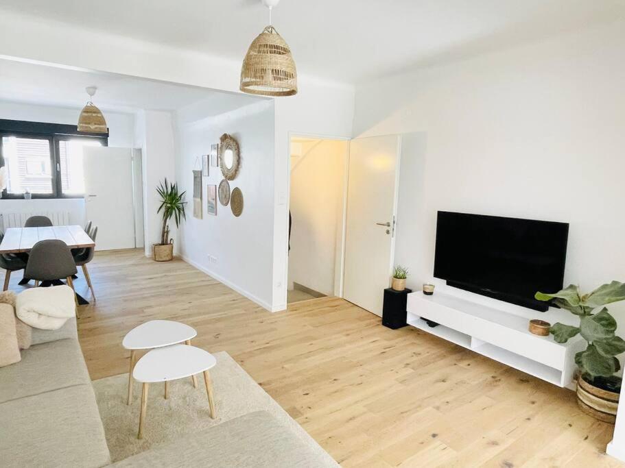 ein weißes Wohnzimmer mit einem Flachbild-TV in der Unterkunft Modern townhouse with Private Garden in Differdingen