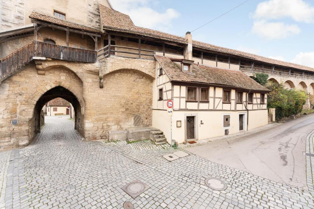 an old building with an archway next to a street at Nächtigen an der Stadtmauer in Rothenburg ob der Tauber