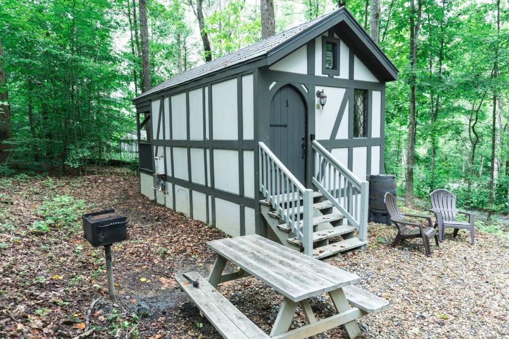 un bâtiment noir et blanc avec un banc et un grill dans l'établissement Tiny Home Cottage Near the Smokies #1 Olga, à Sevierville