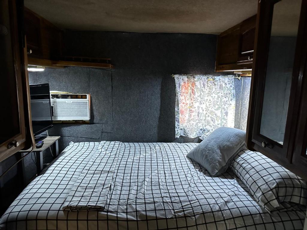 a bedroom with a bed in a room with a window at Studio Black Castle RV in Miami