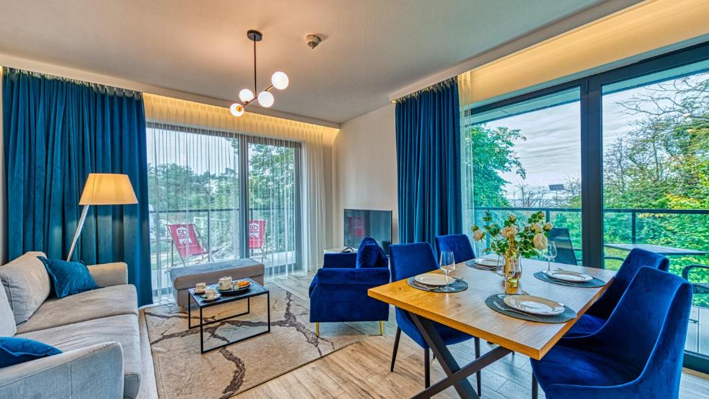 sala de estar con mesa y sillas azules en Rezydencja Niechorze 208 z 2 sypialniami i 2 łazienkami przy Plaży - 5D Apartamenty en Niechorze