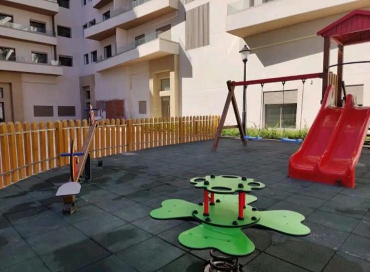 a playground with a slide and a swing at Appartement Calme avec Piscine Mohemmadia Zenata in Aïn Harrouda
