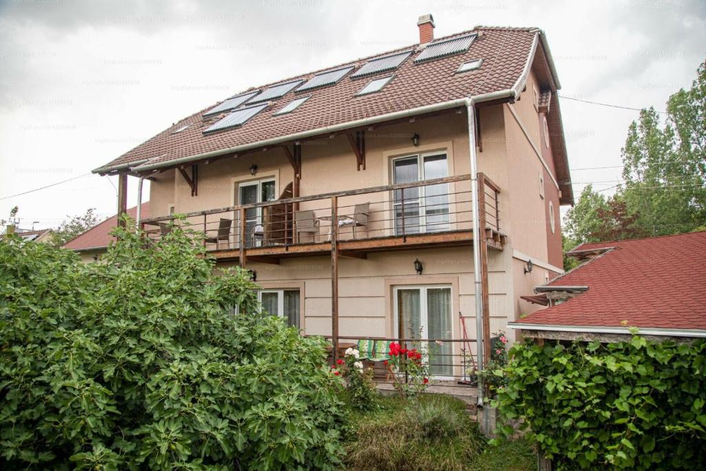 a large house with a balcony and a roof at Sorompó Vendégház in Balatonkenese