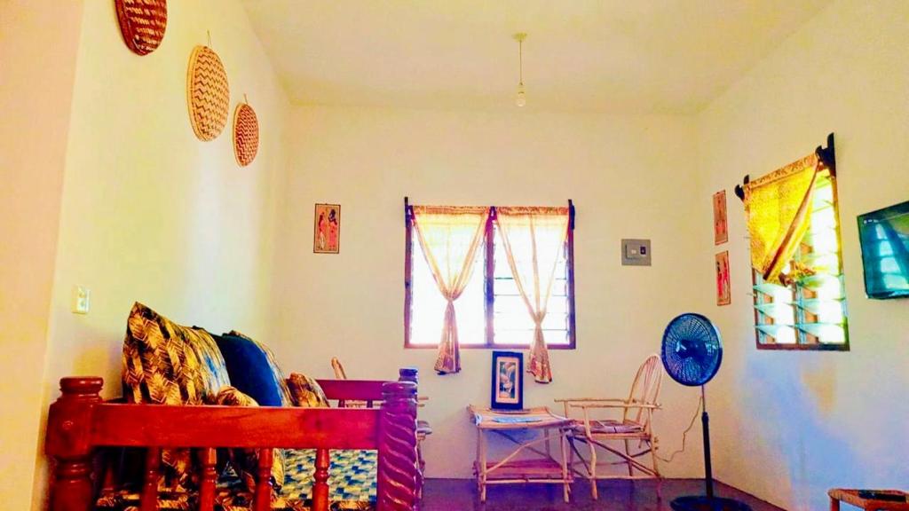 a room with a bed and a table and windows at Mkayamba House in Malindi