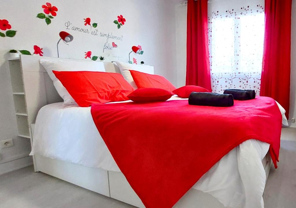 Una cama roja y blanca con una manta roja. en Éclat Méditerranéen - Côte d'Azur en Cagnes-sur-Mer