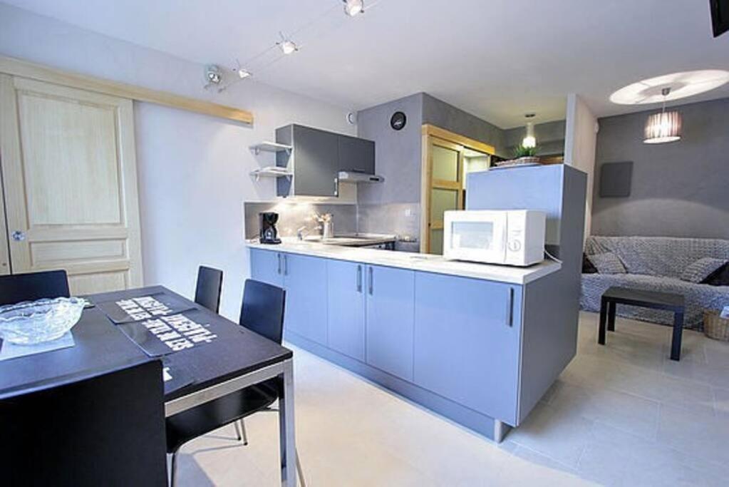 a kitchen with a dining table and a microwave at Appartement avec ascenseur LA DÉFENSE in Courbevoie