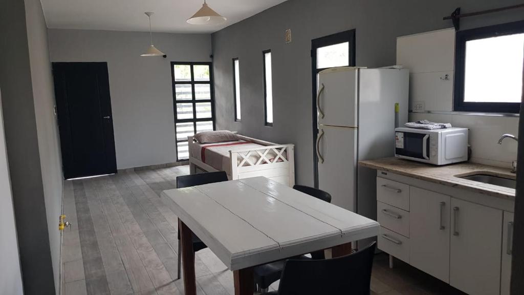 uma cozinha com uma mesa e um frigorífico branco em Alojamiento Soriano em Merlo