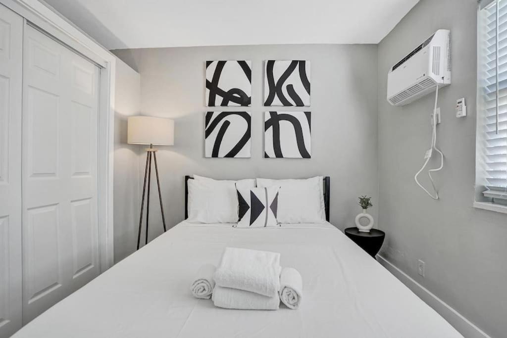ein weißes Schlafzimmer mit einem großen Bett mit Handtüchern darauf in der Unterkunft Rustic Retreats Cozy 1BR For 4 Guests In The Heart Of Fort Lauderdale in Fort Lauderdale