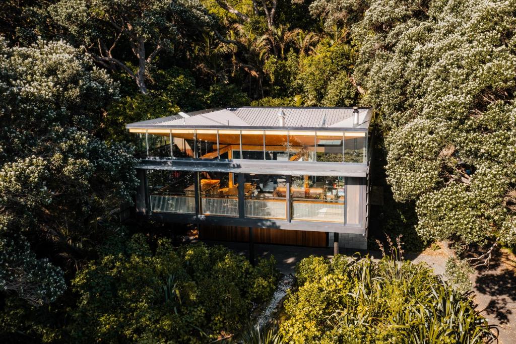 uma vista aérea de uma casa rodeada por árvores em Kawakawa House - Piha Holiday Home em Auckland